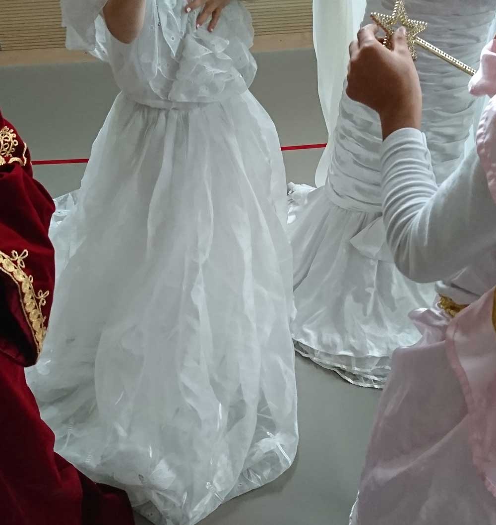 Drei Mädchen und ein Junge tragen Prinzessinnen- und Prinzenkostüme.